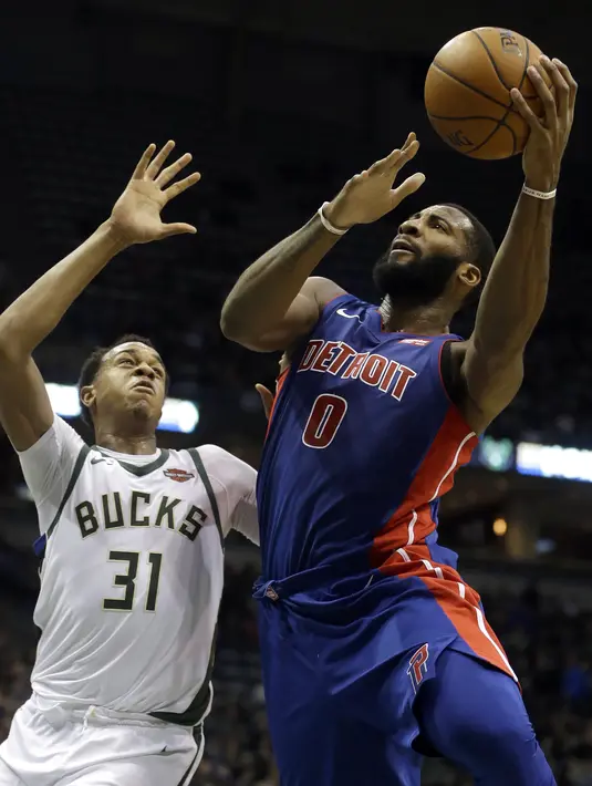 Aksi pemain Detroit Pistons, Andre Drummond (0) saat mencetak poin melewati adangan pemain Bucks, John Henson (31) pada laga NBA basketball game di Bradley Center, Milwaukee, (15/11/2017). Bucks menang 99-95. (AP/Aaron Gash)