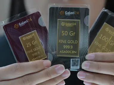 Seorang karyawan menunjukkan emas batangan 25, 50, dan 100 gram produksi Galeri 24, anak perusahaan dari PT Pegadaian (Persero), di Jakarta pada 14 April 2025. (BAY ISMOYO/AFP)
