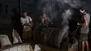 Pekerja memanggang biji kopi robusta dengan cara tradisional di sebuah produsen biji kopi kecil di Banda Aceh (14/11/2020). (AFP/Chaideer Mahyuddin)