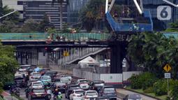 Suasana lalu lintas sekitar proyek Tugu Tenaga Kesehatan di Jembatan Penyeberangan Orang (JPO) Sudirman, Jakarta, Jumat (12/11/2021). Tugu Tenaga Kesehatan dibangun di atas JPO Sudirman. (merdeka.com/Imam Buhori)