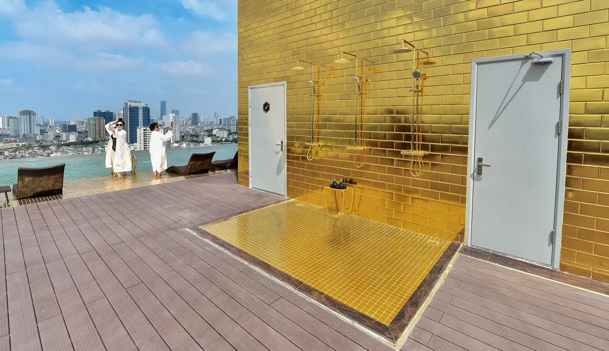 Para tamu berpose di kolam tanpa di hotel Dolce Hanoi Golden Lake yang baru saja diresmikan di Hanoi, Vietnam pada Kamis (2/7/2020). Hotel tersebut merupakan hotel berlapiskan emas 24 karat pertama di dunia. (Manan VATSYAYANA / AFP)