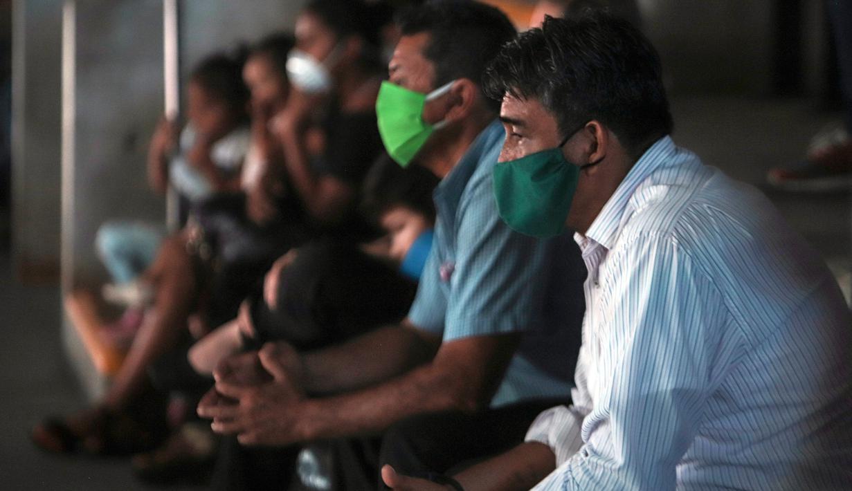 Penonton mengenakan masker saat melihat pertandingan tinju yang dipromotori oleh mantan juara dunia Rosendo Alvarez di Managua, Nikaragua pada 25 April 2020. Nikaragua merupakan salah satu dari sedikit negara yang kegiatan olahraga tetap berjalan di tengah pandemi Covid-19. (AP/Alfredo Zuniga)