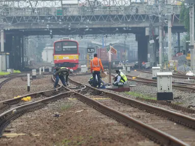Petugas melakukan pengecekan wesel di perlintasan kereta api Cipinang-Jatinegara, Jakarta, Kamis (5/11/2020). Pengecekan perlintasan secara berkala di lakukan KAI untuk mengurangi potensi kecelakaan kereta api. (merdeka.com/Imam Buhori)