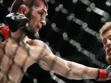 Khabib Nurmagomedov (kiri) meninju Conor McGregor dalam pertarungan UFC 229 di Las Vegas, AS (6/10). Nurmagomedov mengalahkan McGregor dan berhasil keluar sebagai pemenangnya. (AP Photo/John Locher)