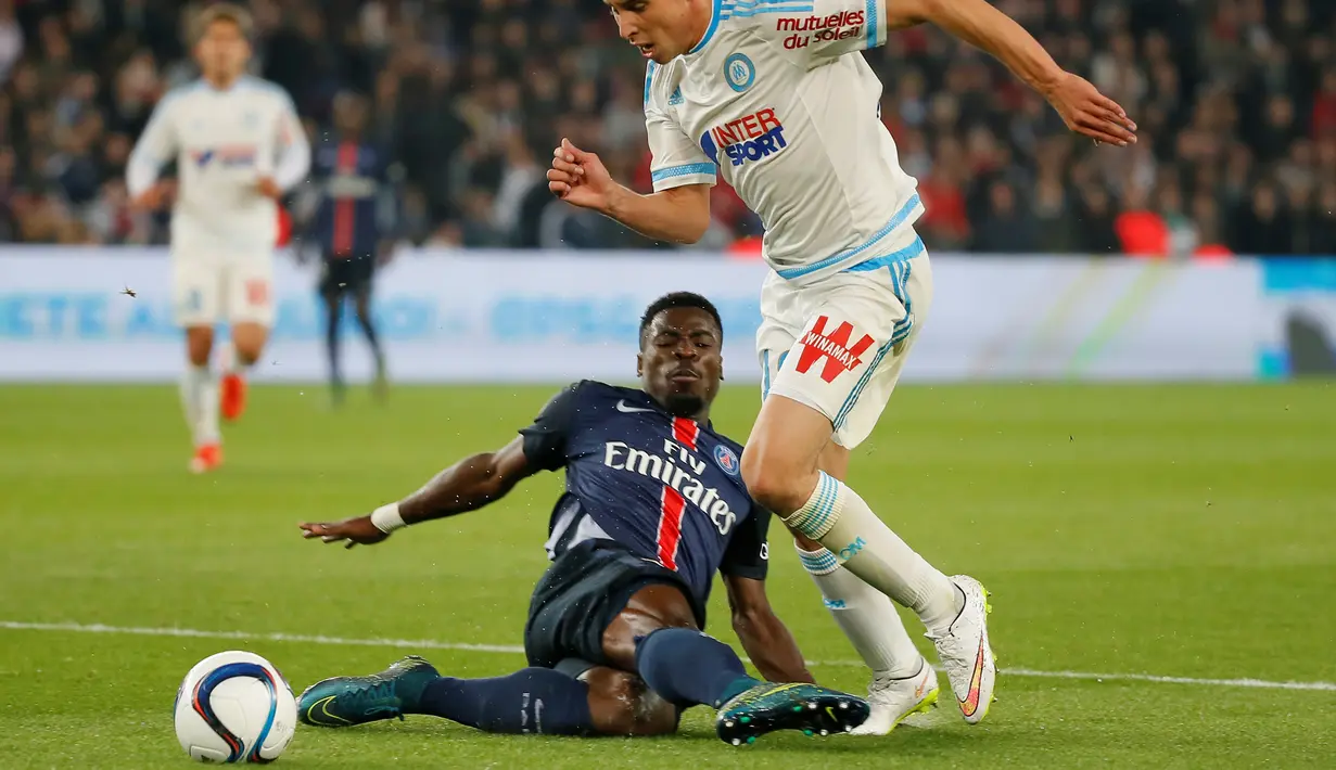 Pemain PSG Serge Aurier (kiri) berebut bola dengan pemain Olympique Marseille dalam lanjutan Liga 1 Perancis di Parc des Princes stadium,Paris, Minggu (04/10/2015). PSG menang 2-1.  (EPA/Ian Langsdon)