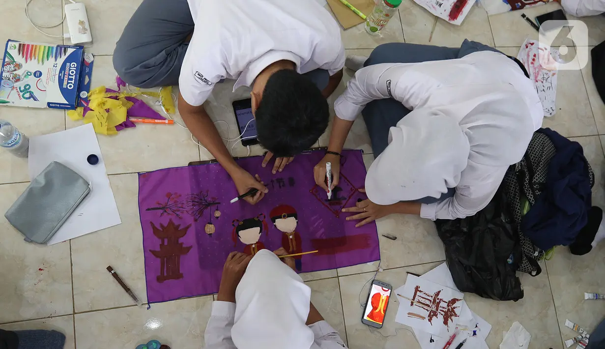 Siswa siswi sedang membuat lukisan bernuansa imlek menggunakan media lampion di SMA Negri 39 Jakarta, Selasa (21/1/2020). Kerajinan lukisan tersebut dibuat oleh siswa untuk menyambut hari imlek 2571 yang jatuh pada Sabtu (25/1) 2020. (Liputan6.com/Herman Zakharia)