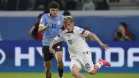 Diego Luna dari Amerika Serikat, kanan, ditantang oleh Alan Matturro dari Uruguay selama pertandingan sepak bola perempat final Piala Dunia U-20 FIFA di stadion Madre de Ciudades di Santiago del Estero, Argentina, Minggu, 4 Juni 2023. (AP Photo/ Nicolas Aguilera)