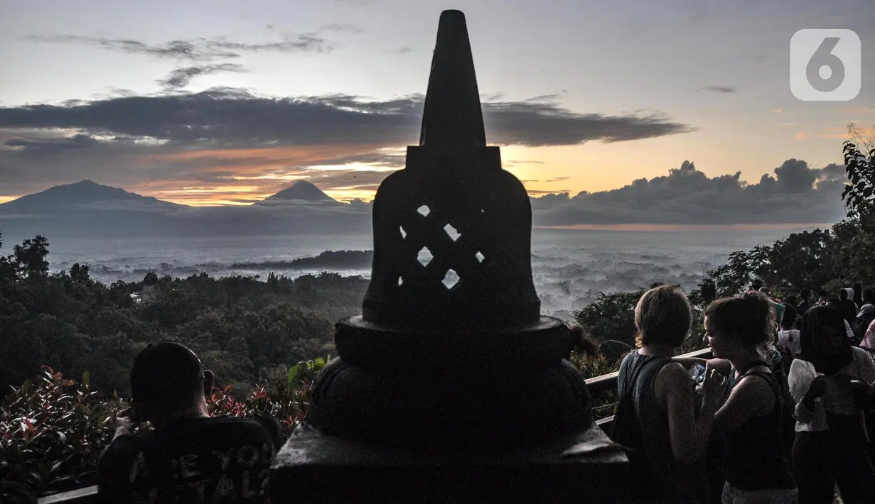 <p>Wisatawan menikmati matahari terbit atau sunrise dengan latar belakang Candi Borobudur di Punthuk Setumbu, Karangrejo, Magelang, Jawa Tengah, Senin (16/5/2022). Punthuk Setumbu menjadi destinasi favorit di Jawa Tengah, terlebih saat libur Waisak yang terkenal dengan keindahan alam Candi Borobudur dan sekitarnya saat matahari terbit. (merdeka.com/Iqbal S. Nugroho)</p>