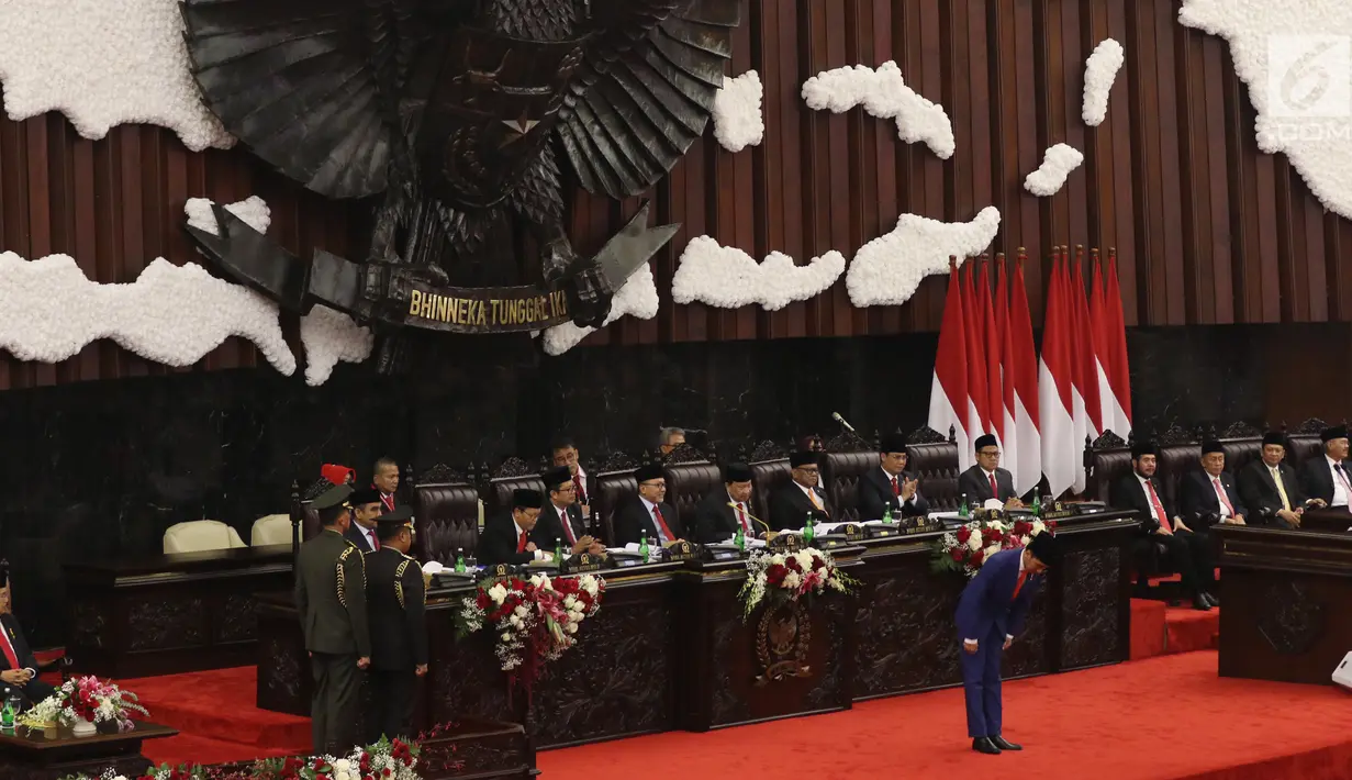 Presiden Joko Widodo membungkukan badan ke arah anggota dewan sebelum menyampaikan Pidato Kenegaraan pada Sidang Tahunan MPR 2019 di Kompleks Parlemen, Senayan, Jakarta, Jumat (16/8/2019). Jokowi akan menyampaikan pidato dalam tiga sesi dengan tema yang berbeda. (Liputan6.com/Johan Tallo)