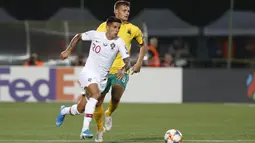 Bek Portugal, Joao Cancelo menggiring bola dari kejaran pemain Lithuania, Karolis Laukzemis pada pertandingan grup B Kualifikasi Euro 2020 di stadion LFF di Vilnius (10/9/2019). Portugal menang telak atas Lithuania 5-1. (AP Photo/Mindaugas Kulbis)