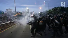 Aparat kepolisian melepaskan tembakan gas air mata untuk membalas serangan petasan yang dilemparkan oleh demonstran di sekitar Gedung DPR RI, Jakarta, Senin (30/9/2019). Demo mahasiswa dan sejumlah elemen tersebut berakhir dengan bentrok dengan polisi. (Liputan6.com/Immanuel Antonius)