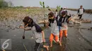 Para murid membawa bibit mangrove untuk di tanam di Pesisir Pantai Muara Karang, Jakarta, Kamis (29/10). 5.000 bibit baru ditanam untuk memperkuat ekosistem yang telah dibangun dan memperbesar manfaat terhadap masyarakat. (Liputan6.com/Faizal Fanani)