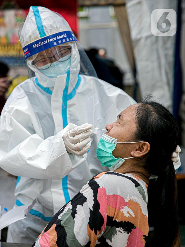 Petugas medis melakukan swab antigen terhadap pengungsi banjir di Universitas Borobudur, Cipinang Melayu, Jakarta, Minggu (21/2/2021). Pengungsi diwajibkan menjalani swab antigen untuk mencegah penyebaran COVID-19. (Liputan6.com/Faizal Fanani)