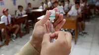 Seorang paramedis menyiapkan vaksin difteri untuk diberikan kepada siswa di sebuah sekolah dasar pada hari pertama sebuah kampanye di Tangerang, Senin (11/12). (AP Photo / Tatan Syuflana)