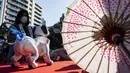 Pemilik robot anjing “aibo" (kiri) melihat hewan peliharaan saat dipajang menjelang upacara untuk menandai Festival Shichi-Go-San di Kuil Kanda Myojin, Tokyo, Jepang, Jumat (11/11/2022). Lebih dari 60 pemilik "aibo" menghadiri acara tradisional yang diadakan setiap tahun dengan mendoakan kesehatan yang baik di masa depan untuk anak perempuan berusia tiga dan tujuh tahun dan anak laki-laki berusia lima tahun. (Richard A. Brooks / AFP)