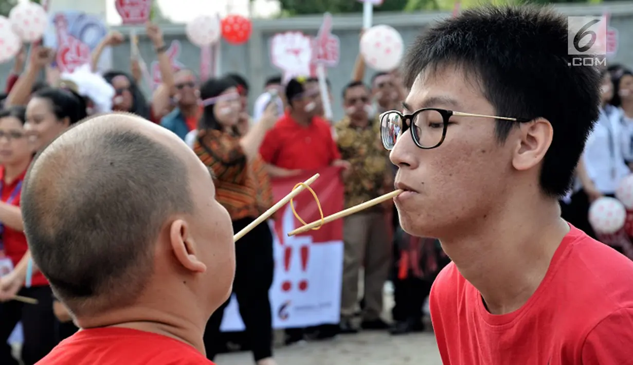 Dua karyawan mengikuti lomba memasukan bambu supit ke dalam karet dalam rangka HUT Kemerdekaan RI di Gedung OT Cengkareng, Jakarta, Jumat (17/8). Kegiatan ini mengusung visi baru "GO BEYOND" dengan slogan Lawan Puasmu. (Liputan6.com/HO/Iwan)