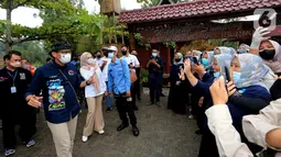 Menteri Pariwisata dan Ekonomi Kreatif Sandiaga Uno (kiri) menyapa warga pada kunjungannya di Desa Wisata Saung Ciburial, Kecamatan Samarang, Garut, Jawa Barat, Senin (18/10/2021). Hujan deras tidak menyurutkan warga untuk menyambut kunjungan kerja Sandiaga Uno. (Liputan6.com/HO/Parekraf)
