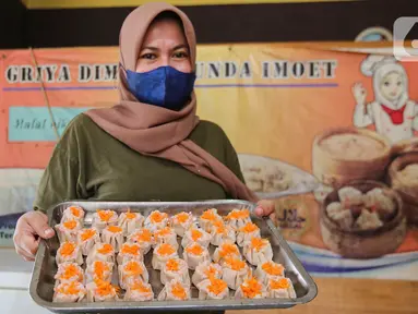 Wiwin, pemilik yang juga seorang guru menunjukkan dimsum di Griya Dimsum Bunda Imoet, Serua, Tangerang Selatan, Rabu (9/2/2022). UMKM dimsum yang berdiri sejak tahun 2020 di awal pandemi mampu memproduksi lebih dari 100 pak atau lebih dari 1000 buah dimsum per hari. (Liputan6.com/Fery Pradolo)