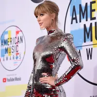 Penyanyi Taylor Swift menghadiri ajang American Music Awards 2018 di Los Angeles, Selasa (9/10). Mengenakan mini dress silver dari Balmain, Taylor langsung menjadi pusat perhatian begitu melangkah di red carpet. (Kevork Djansezian/Getty Images/AFP)