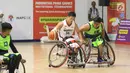Pebasket difable Indonesia, Donald P Santoso (tengah) mencoba menembus kawalan pemain Malaysia pada laga Indonesia Para Games Invitational Tournament 2018 di Hall A Senayan, Jakarta, Minggu (1/7). Indonesia unggul 54-53. (Liputan6.com/Helmi Fithriansyah)