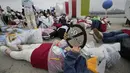 <p>Aktivis lingkungan mengenakan pakaian yang terbuat dari sampah plastik berbaring di tanah selama kampanye untuk memperingati Hari Bumi melawan perubahan iklim di Seoul, Korea Selatan, Jumat (22/4/2022). (AP Photo/Ahn Young-joon)</p>