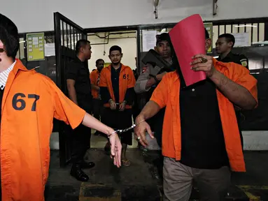 Tersangka berjalan menuju mobil tahanan usai jalani sidang perdana dugaan terorisme di Pengadilan Negeri Jakarta Barat, Senin (12/10/2015). Sebanyak tujuh orang tersangka diduga terkait dengan organisasi radikal  ISIS. (Liputan6.com/Immanuel Antonius)