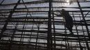 Seorang nelayan wanita mengeluarkan ikan dari struktur yang terbuat dari tiang bambu setelah dijemur di sebuah koloni nelayan di Mumbai, India, Rabu (29/12/2021). (AP Photo/Rafiq Maqbool)