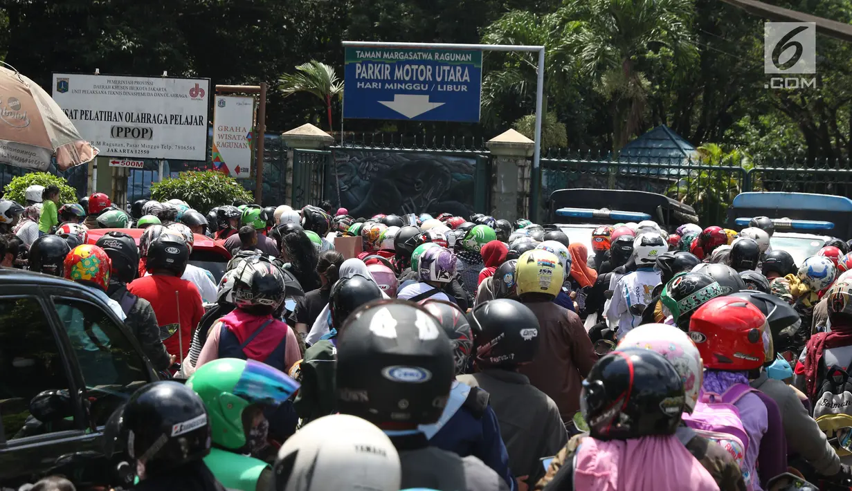 Warga memadati lajur pintu masuk area parkir motor kawasan Kebun Binatang Ragunan, Jakarta, Minggu (30/12). Libur panjang jelang pergantian tahun dimanfaatkan warga untuk berlibur di kawasan Kebun Binatang Ragunan. (Liputan6.com/Helmi Fithriansyah)