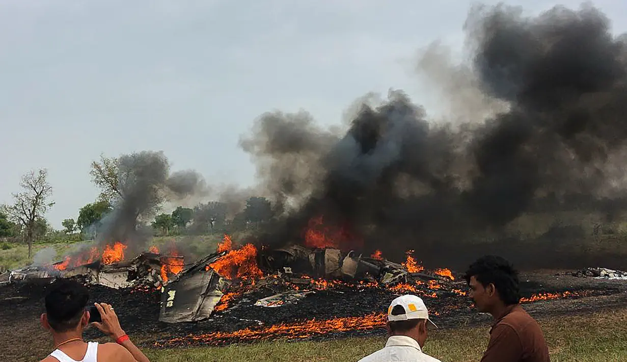 Sejumlah warga melihat pesawat MiG-27 yang terbakar setelah jatuh saat misi rutin di sekitar desa Devariya dekat Jodhpur, India, (4/9). Menurut media lokal, pilot pesawat selamat dan tidak ada korban jiwa akibat insiden tersebut. (AFP Photo)