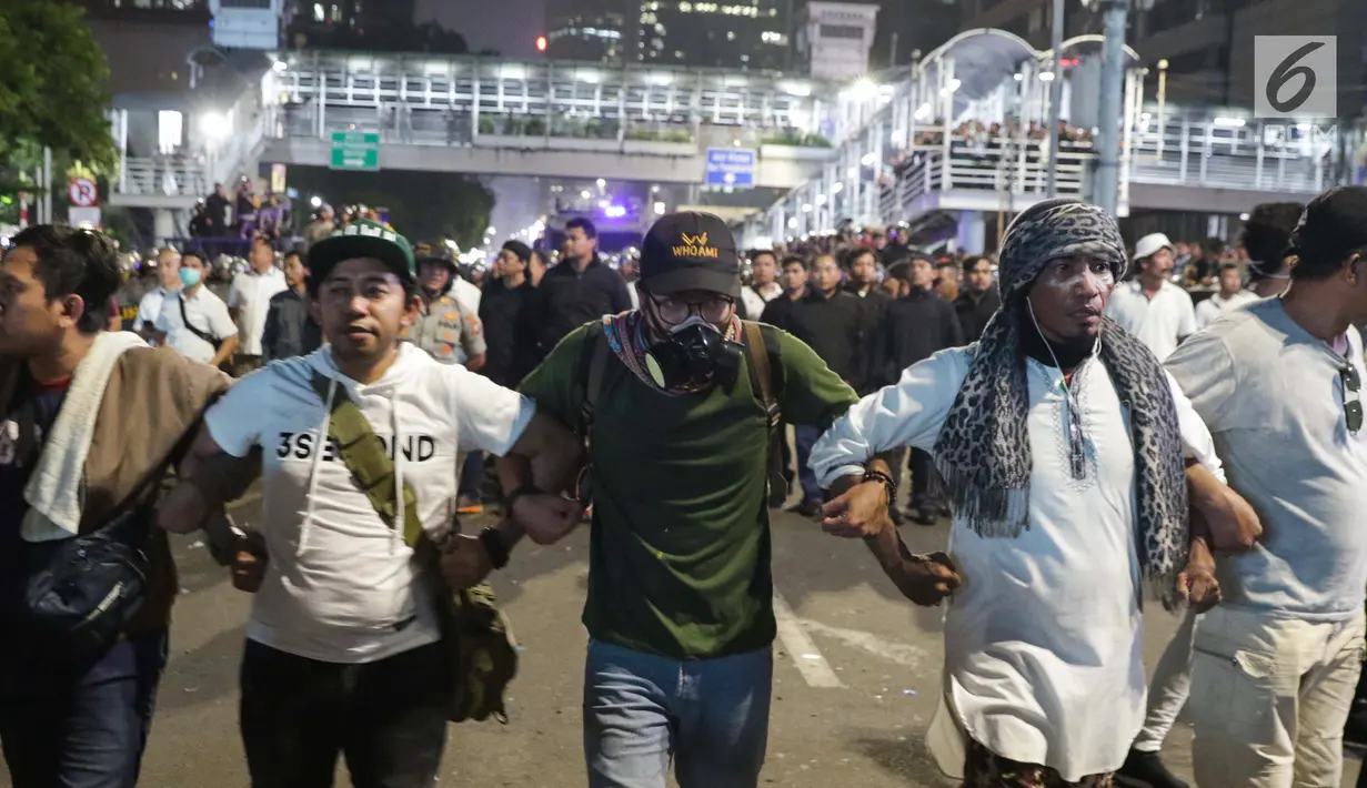 Peserta aksi massa Gerakan Nasional Kedaulatan Rakyat mebuat pagar badan saat membubarkan diri usai unjuk rasa di depan Gedung Bawaslu, Jakarta, Selasa (21/5/2019). Mereka meminta Bawaslu memeriksa hasil Pemilu 2019 yang dinilai banyak kecurangan. (Liputan6.com/Helmi Fithriansyah)