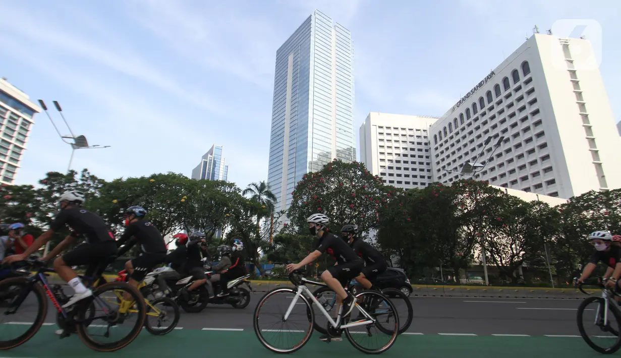 Pesepeda melintas Jalan Sudirman pada peluncuran jersey bersepeda Unlimited Hope hasil kokreasi Smartfren, Show The Monster dan Common Spot di Jakarta, Sabtu (27/3/2021). Hasil jersey bersepeda akan digunakan untuk pemberdayaan UMKM melalui Teman Kreasi Indonesia. (Liputan6.com/Pool)