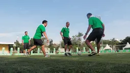 Kurniawan Dwi Yulianto dan para pelatih lainnya melakukan pemanasan sebelum berbagi tips untuk siswa Sekolah Dasar pada ajang Milo Football Clinic Day, Minggu (30/10/2016) di Simprug. (Bola.com/Nicklas Hanoatubun)