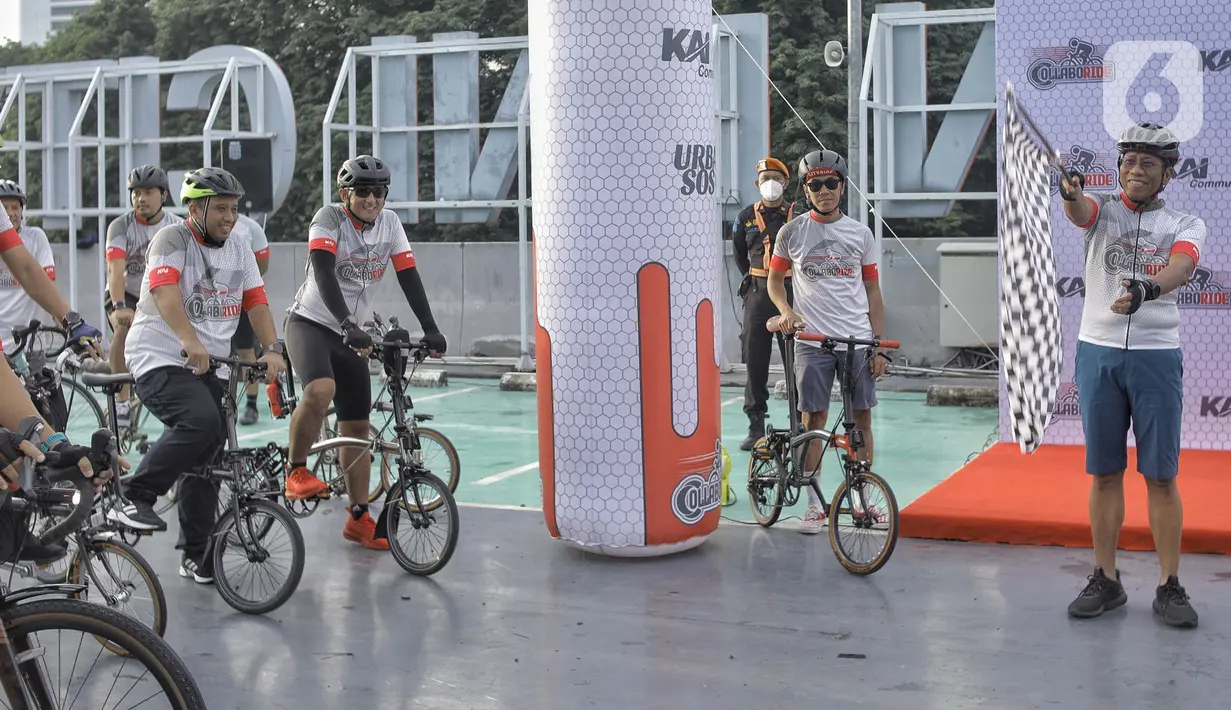 Direktur Utama PT KAI Didiek Hartantyo (kanan) mengibarkan bendera saat melepas peserta sepeda bersama berbagai komunitas Urban SOS Cycling Club di Stasiun BNI City, Jakarta, Sabtu (21/1/2023). Kegiatan olahraga bersepeda yang bertajuk Collaboride digelar dalam rangka mempromosikan Stasiun BNI City sebagai area transportasi publik yang dapat digunakan untuk aktivitas warga. (Liputan6.com/Angga Yuniar)