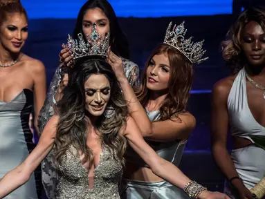 Izabele Coimbra disematkan mahkota Miss T Brasil 2017 setelah dinobatkan sebagai pemenang kontes kecantikan transgender di Sao Paulo, 21 April 2017. Izabele akan mewakili negaranya ke ajang Miss International Queen 2018 di Thailand. (NELSON ALMEIDA/AFP)