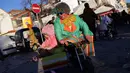 Seorang pria bersama anaknya mengenakan kostum badut saat mengikuti Parade Karnaval Clowns di pantai Sesimbra, Lisbon, Spanyol (12/2). Acara ini digelar setiap tahun. (AP Photo / Armando Franca)