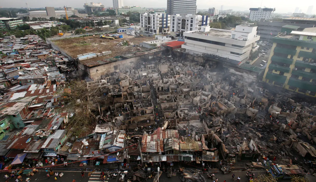 Suasana pemukiman warga yang hangus setelah kebakaran di kota Quezon, Metro Manila di Filipina (28/12). Menurut laporan, sekitar 500 rumah ludes terbakar dan sekitar 1.000 keluarga telah diungsikan. (REUTERS/Erik De Castro)