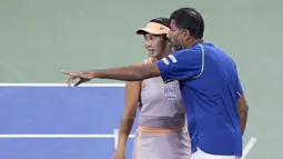 Petenis Indonesia, Aldila Sutjiadi (kiri) berbincang dengan petenis India, Rohan Bopanna saat bertanding melawan petenis ganda campuran Amerika Serikat, Taylor Townsend/Donald Young pada laga semifinal US Open 2024 yang berlangsung di di Stadion Louis Amstrong, New York, Amerika Serikat, Rabu (04/09/2024) WIB. (AP Photo/Eduardo Munoz Alvarez)