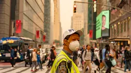 Pengunjung Times Square di New York tampak tidak terganggu oleh asap kebakaran hutan pekat yang menyelimuti area tersebut pada hari Rabu, 7 Juni.  (David Dee Delgado/Getty Images/AFP)