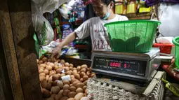 Pedagang menimbang telur di Pasar Tebet Timur, Jakarta, Jumat (11/6/2021). Kementerian Keuangan menyatakan kebijakan tarif Pajak Pertambahan Nilai (PPN), termasuk soal penerapannya pada sembilan bahan pokok (sembako), masih menunggu pembahasan lebih lanjut. (Liputan6.com/Faizal Fanani)