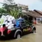 Untuk membantu masyarakat yang akan menyeberang, polisi menggunakan mobil patroli.
