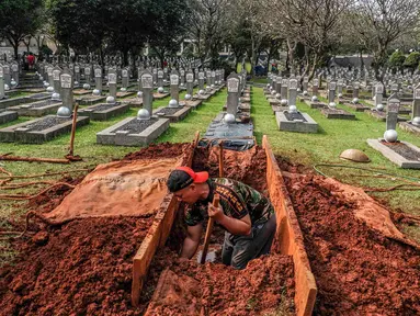 Petugas menggali tanah untuk makam almarhumah Ani Yudhoyono, istri Presiden Ke-6 RI yang berada di Blok M 129 Taman Makam Pahlawan (TMP) Kalibata, Jakarta, Sabtu, (01/6/2019). Lokasi makam berdampingan dengan makam istri Presiden B.J Habibie, Ainun Habibie. (Liputan6.com/Faizal Fanani)