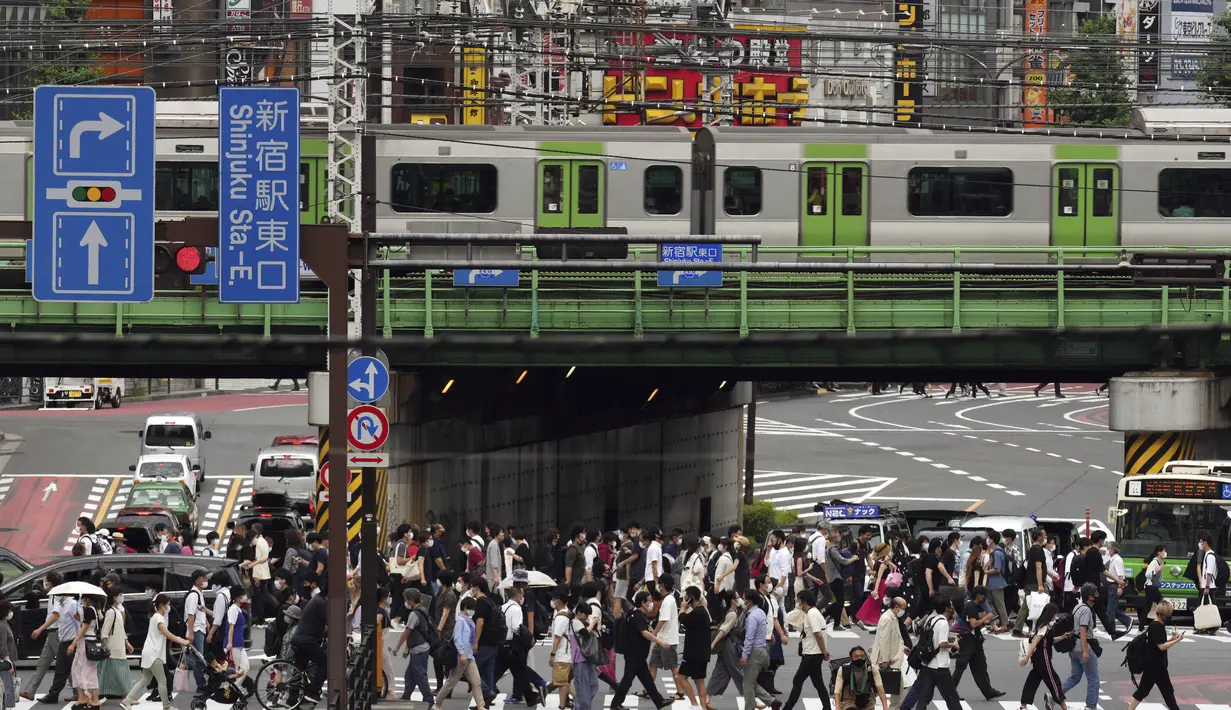 Orang-orang berjalan di sepanjang penyeberangan pejalan kaki di Tokyo, Selasa (22/6/2021). Ibu kota Jepang mengkonfirmasi lebih dari 430 kasus virus corona baru pada hari Selasa. (AP Photo/Eugene Hoshiko)