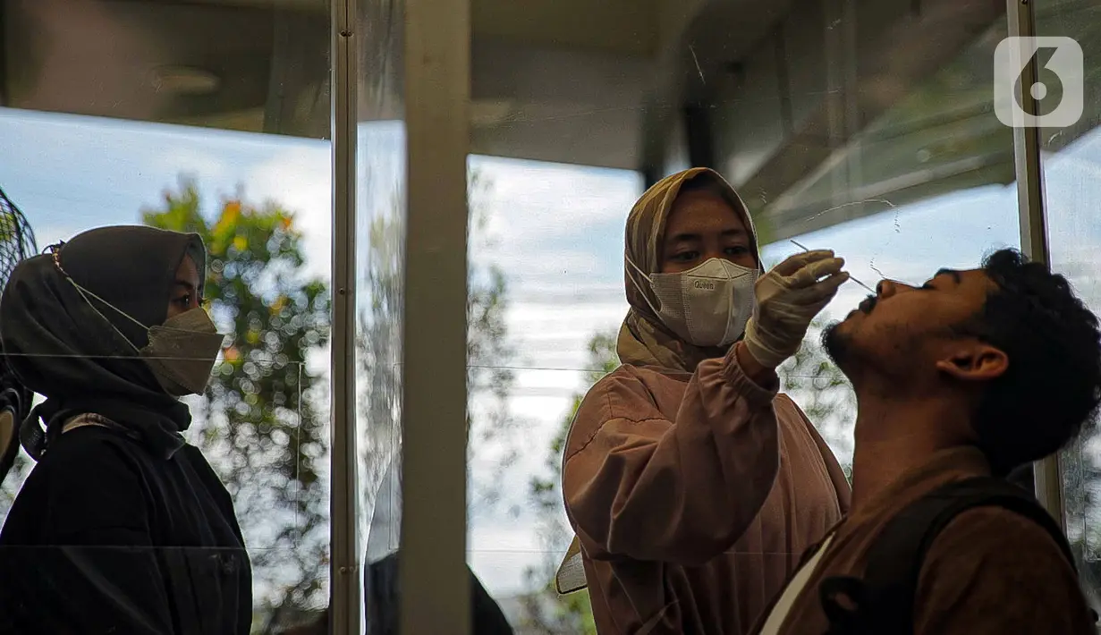 Calon penumpang menjalani tes swab PCR di Stasiun Pasar Senen, Jakarta, Jumat (24/12/2021). Layanan ini untuk membantu masyarakat dalam melengkapi persyaratan naik kereta pada masa Natal dan Tahun Baru. (Liputan6.com/Faizal Fanani)