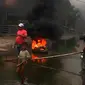 Warga membakar ban mobil bekas karena jalan di perbatasan Kabupaten Gowa dan Kota Makassar, kerap banjir dan tergenang. (Liputan6.com/Ahmad Yusran)