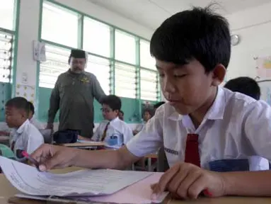 Ketua Persatuan Guru Republik Indonesia (PGRI) Provinsi Aceh, Ramli Rasyid meninjau pelaksanaan ujian sekolah dasar di SD Budi Darma Banda Aceh, Senin (2/4). Ujian bagi siswa SD, MIN dan SDLB diikuti 4.138 peserta yang berlangsung mulai 2 hingga 10 April 2012. (Antara)