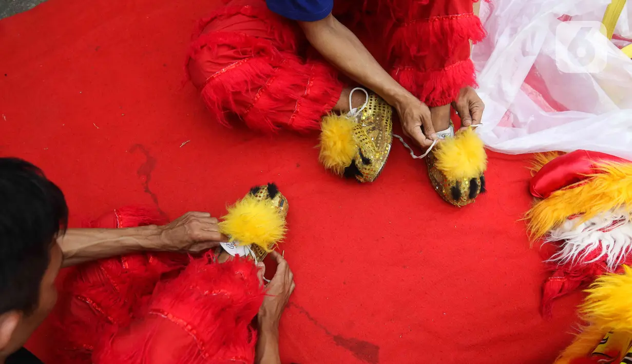 Pemain dari kelompok barongsai Naga Merah Putih Bogor bersiap melakukan latihan dengan Barongsai di kawasan Babakan Pasar, Kota Bogor, Jawa Barat, Rabu (11/1/2023). Latihan tersebut  untuk mempersiapkan penampilan menyambut Tahun Baru Imlek. (Liputan6.com/Herman Zakharia)