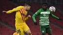 Bek Barcelona, Clement Lenglet, berebut bola dengan gelandang Ferencvaros, Tokmac Nguen, pada laga lanjutan Liga Champions di Puskas Arena, Kamis (3/12/2020) dini hari WIB. Barcelona menang 3-0 atas Ferencvaros. (AFP/Attila Kisbenedek)