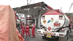 Petugas Pertamina menyedot sisa isi bahan bakar pada truk tangki yang terbakar di SPBU Jalan Kahfi 2, Jagakarsa, Jakarta, Sabtu (30/12). Tidak ada korban jiwa atas insiden itu karena SPBU tidak beroperasi saat kejadian. (Liputan6.com/Herman Zakharia)
