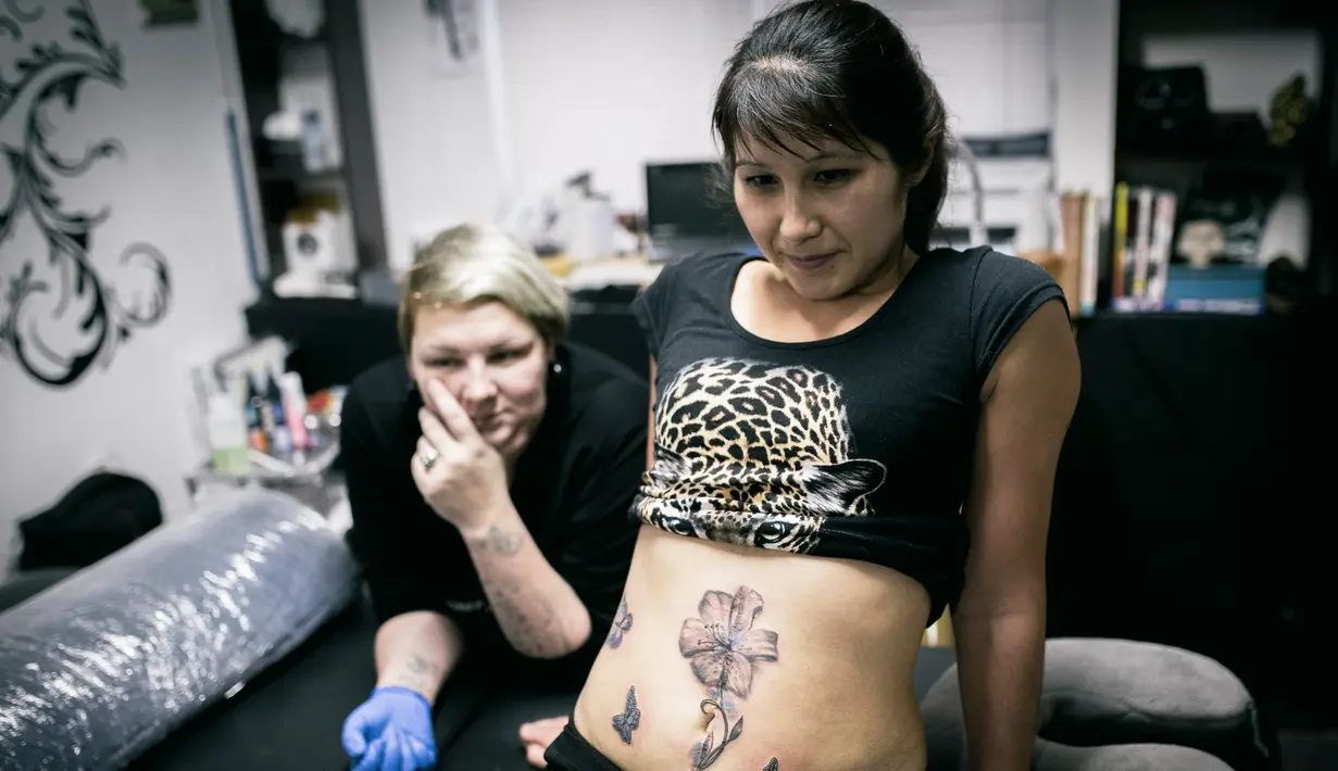 Seorang korban KDRT, Lyaysan menunjukkan tato baru buatan Seniman  Yevgeniya Zakhar di Ufa, Rusia, 31 Januari 2017. Bekas luka para korban KDRT ditato bergambar motif floral oleh Yevgeniya Zakhar. (AP Photo/Vadim Braydov)