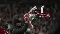 Pelatih Liverpool, Jurgen Klopp mengangkat piala Carabao Cup saat melakukan selebrasi usai pertandingan Final Carabao Cup di Stadion Wembley, London, Senin (28/2/2022). Liverpool memenangkan adu penalti 11-10 setelah pertandingan berakhir imbang 0-0. (AP Photo/Alastair Grant)